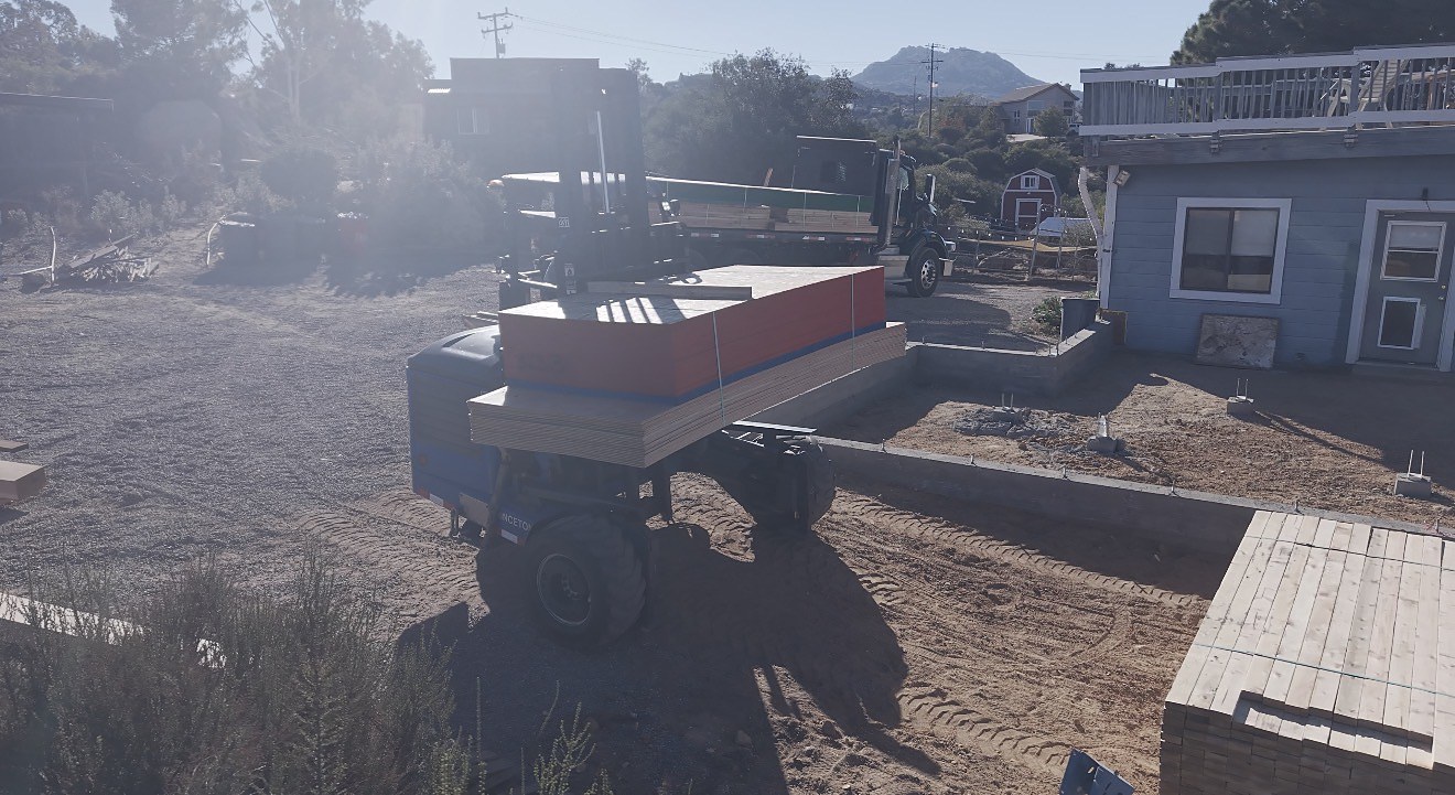 Forklift delivering sheathing and lumber package