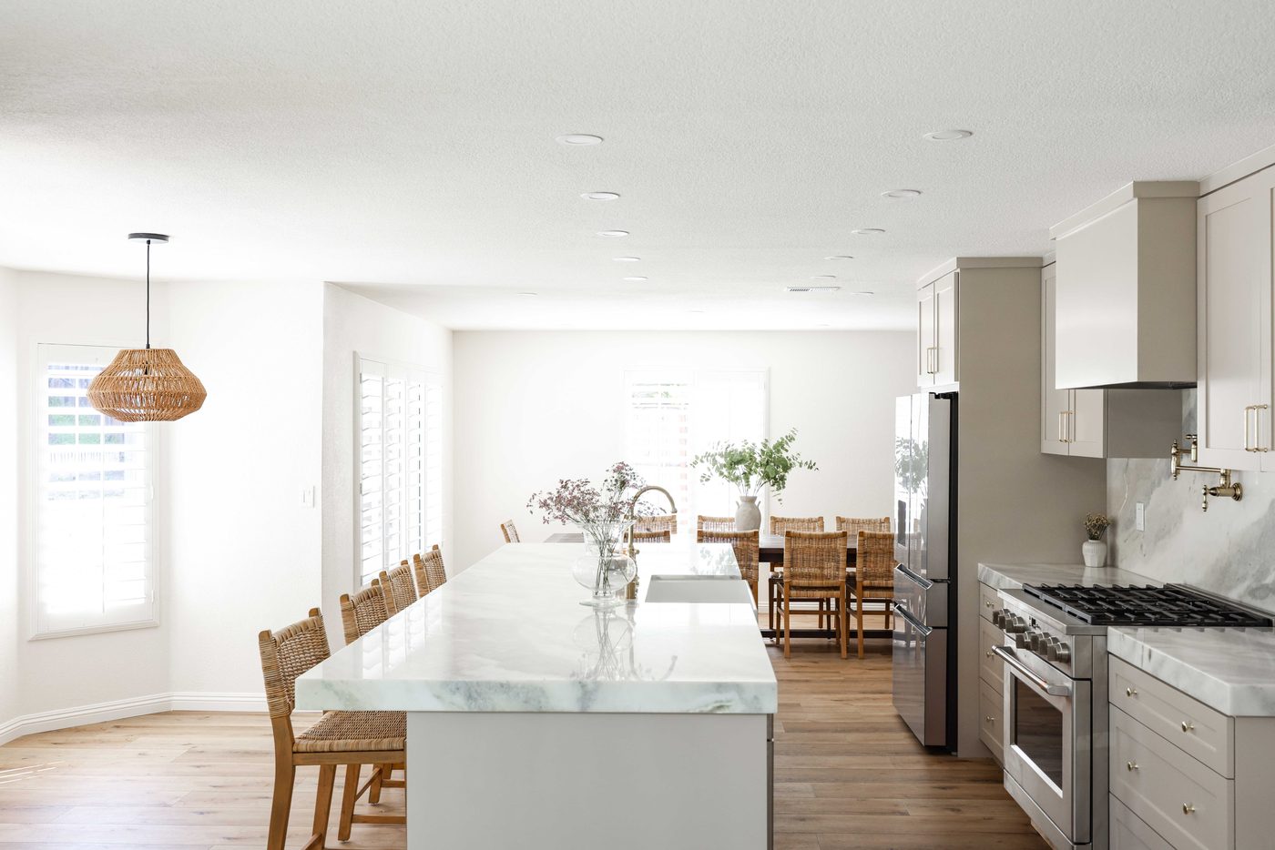 Trailridge kitchen after renovation — marble waterfall island, brass fixtures, dining beyond