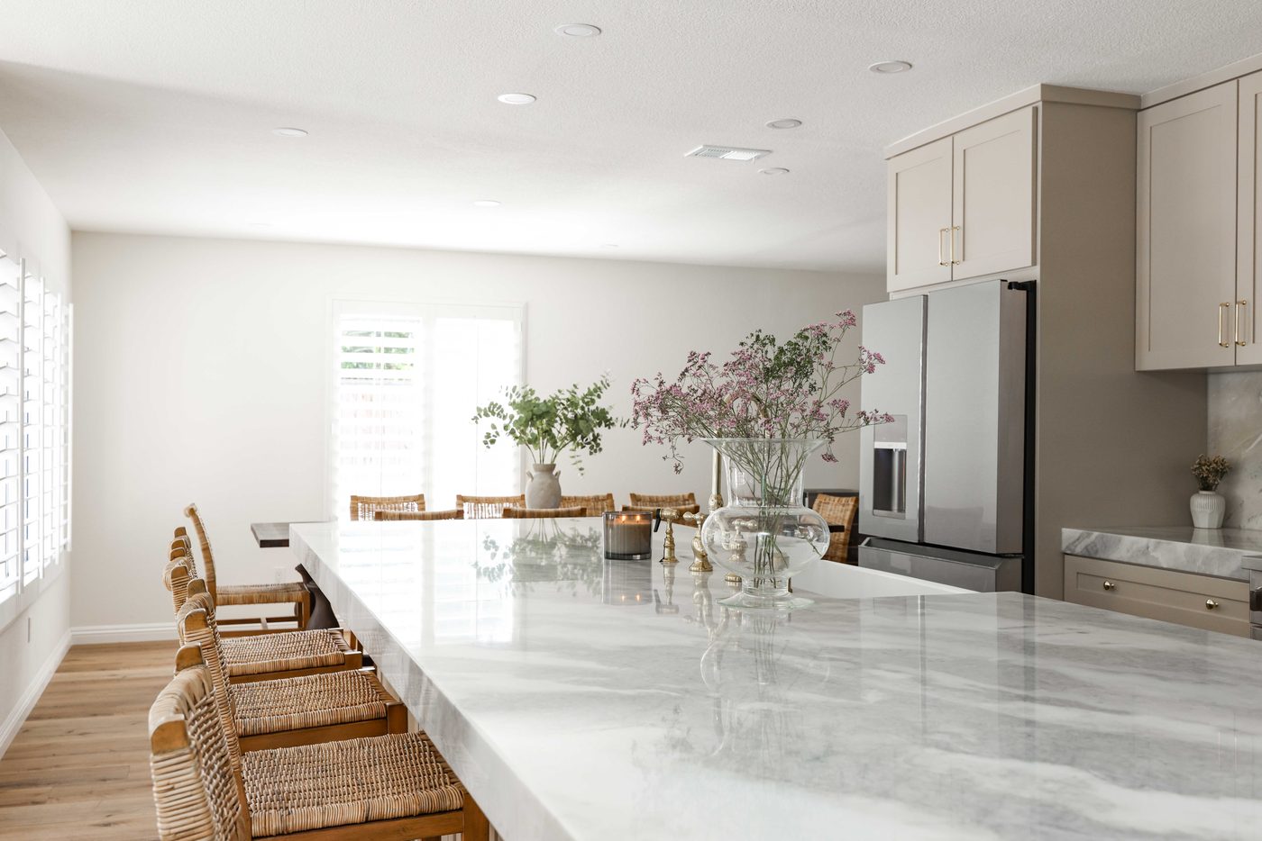 Kitchen after — marble counters, brass faucet, vaulted feel